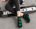 Chaussettes noires avec feuilles de cannabis vertes